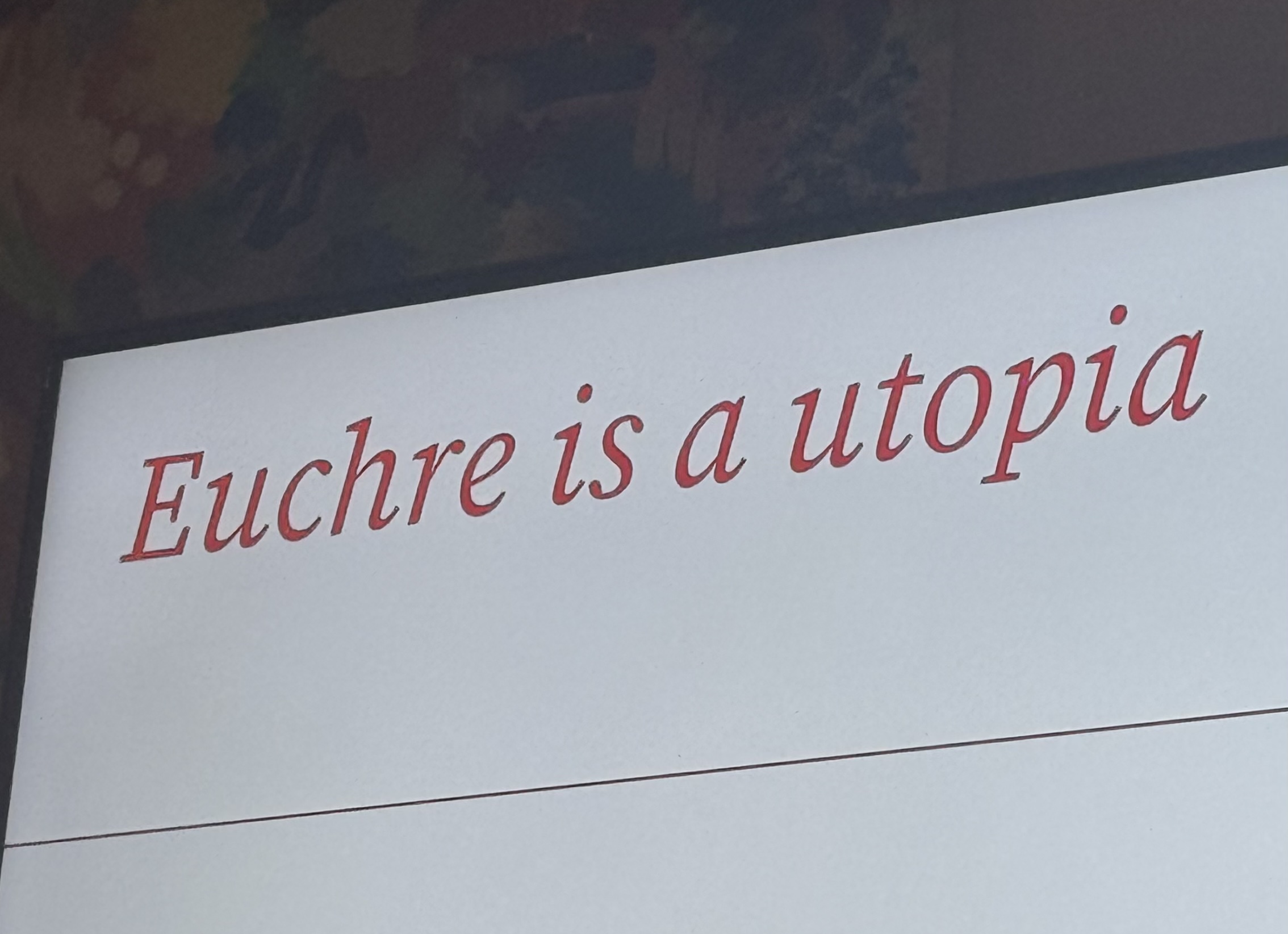a photo of a presentation slide that reads "euchre is a utopia."