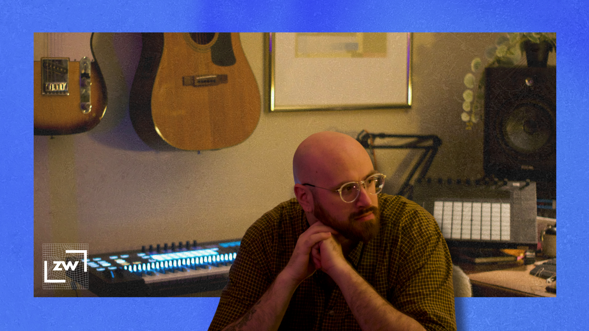 Image of me sitting at my desk against a blue backdrop